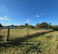 Gardens in Dvory nad Žitavou with a spacious plot and fencing, blue sky.