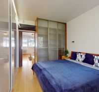 A bedroom in a 4-room apartment with a bed, wardrobes, and decorations on the walls.