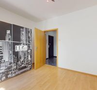 A room in a 4-room apartment with wooden floor decor and wall graphics.