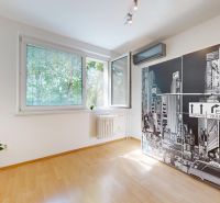 A room with a sunlit window, a black-and-white picture, and a floor with a wooden decor in a 4-room apartment.