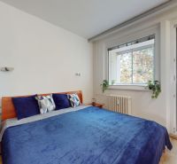 Bedroom with a wide bed, nightstands, and a plant in a 4-room apartment.