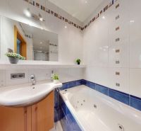 Bathroom with a shower and a bathtub in a 4-room apartment, white tiles with blue decor.