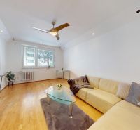 Living room in a 4-room apartment with a wooden decor floor and a comfortable couch.