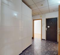 Hallway with a white wardrobe and black doors in a 4-room apartment.