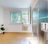 A room with a wooden decor floor in a 4-room apartment, decor on the wall.