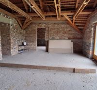 Exposed brick walls and uncovered wooden beams in a family house.