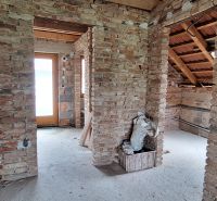 Masonry walls and roof structure in a family house without finished surfaces.