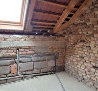 The attic of a family house with wooden beams and a skylight.