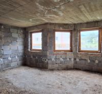 Unfinished room with windows and concrete floor in a family house.