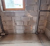 Renovation of a bathroom in a family house with a view of masonry and pipes.