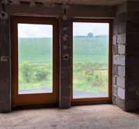 A family house with a view of the green landscape through large windows.