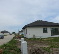 A family house in the village of Reca with a side access road and parked cars.