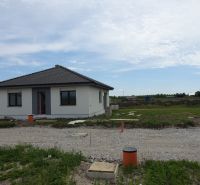 A family house in Reca, simple structure with grassy surroundings and a gravel access road.