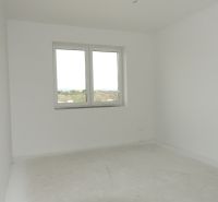 An empty room in a family house with white walls and a window.