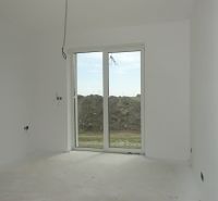 Interior of a family house with white walls and a large window without flooring.