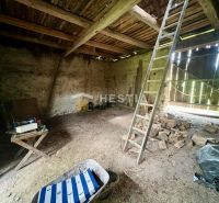 Interior of a family house with a ladder, table, and wood on the floor.