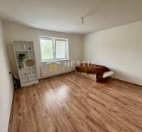Room in a family house with a bed, shelf, and floor with wooden decor.