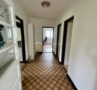 A hallway in a family house with checkered flooring and white walls.