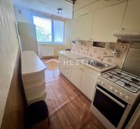 A kitchen in a 3-room apartment with a wooden decor floor and a gas stove.