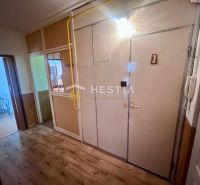 Entrance hall in a 3-room apartment with a wooden decor floor and a table with two chairs.