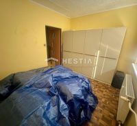 A room in a 3-room apartment with a wooden decor floor and simple furnishings.