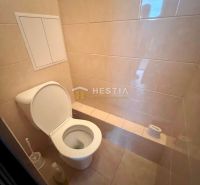 A bathroom with a toilet in a 3-room apartment with predominantly beige tiles.
