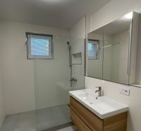 Bathroom in a 2-room apartment with a modern shower and sink.