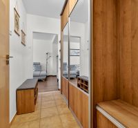 Entrance hall in a 3-room apartment with built-in mirrored wardrobes and a floor with a wooden decor.