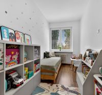 Children's room with a bed, bookshelves, and a floor with a wooden decor, 3-room apartment.