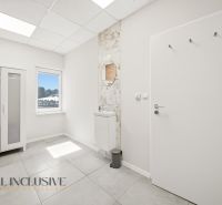 Interior of commercial premises with a white wardrobe, a mirror, and a tiled floor.