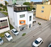 A building with commercial spaces on Obrancov mieru street in Galanta, with cars parked in front of it.