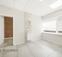 Interior of commercial spaces with white walls, tiles, and a large window.