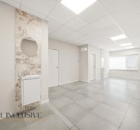 Commercial premises with ceramic flooring, light-colored walls, and a sink with a round mirror.