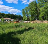 Land - housing in Spišský Hrhov with a view of houses and a green forest in the background.