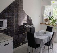 Dining area in a 3-room apartment with a modern table and tiles on the wall.
