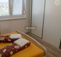 A bedroom with a bed, built-in wardrobe, and wooden decor flooring in a 3-room apartment.