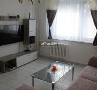 Living room in a 3-room apartment with white walls and a TV on the wall.