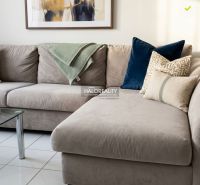 A comfortable sofa in a 3-room apartment, complemented by decorative pillows and a painting on the wall.
