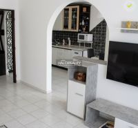 A kitchen with white furniture and black and white tiles in a 3-room apartment.