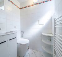 Bathroom with a shower and white tiles in a 2-room apartment.