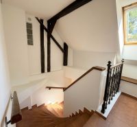 Interior with wooden staircase and large window in a 2-room apartment.