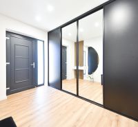 Interior of a family house with black doors and a wooden decor floor.