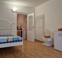 Bedroom with a white bed and storage space, floor with wood decor.