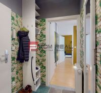Entrance hall with a coat rack and wallpaper with a brick wall motif.