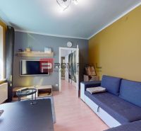 Living room with a blue sofa, TV on the wall, and a floor with a wooden decor.