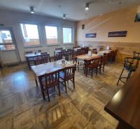 Interior of a gastro space with wooden tables, chairs, and a floor with a wooden decor.