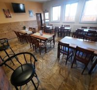 Restaurant spaces with tables and chairs, wooden decor flooring, decorations on the walls.