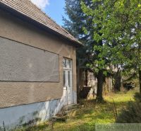 A cottage in Divín with a stone foundation and surrounded by greenery in a peaceful environment.
