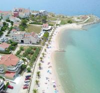 A view of the coastal area of Povljana with the beach and surrounding buildings.
