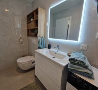 Bathroom in a 3-room apartment with a large mirror and cabinets.
